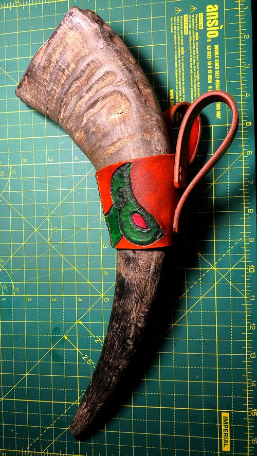 leather horn holder with a raw horn.