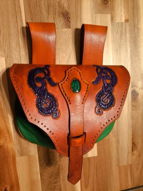 Fantasy leather pouch in brown and green with a green gem and a violet nordic dragon design.