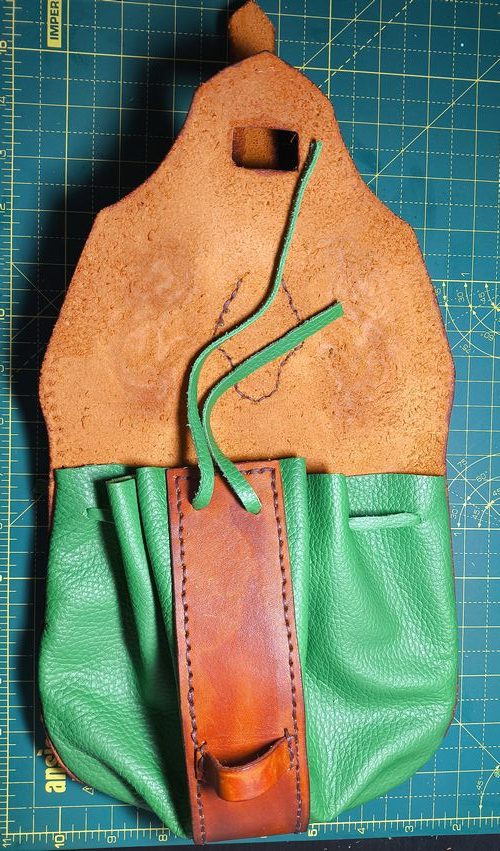 Fantasy leather pouch in brown and green with a green gem and a violet nordic dragon design.