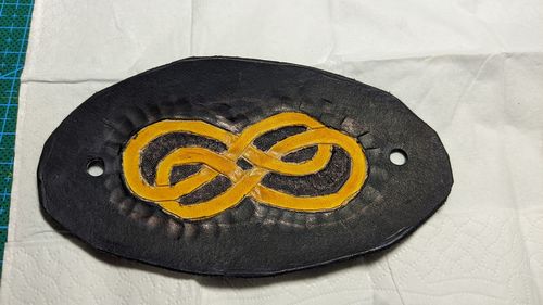 Black leather hairpin with a yellow infinite double loop.