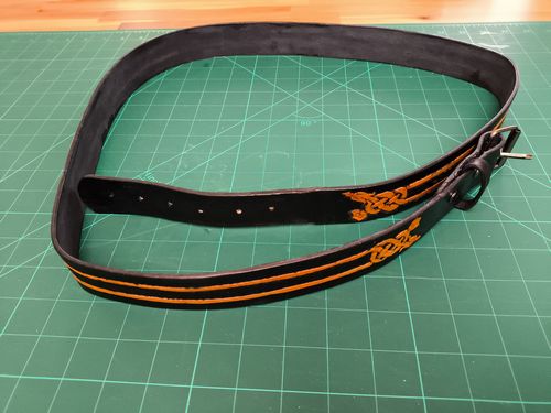 Black leather belt with a yellow dragon carved in a Celtic design style.